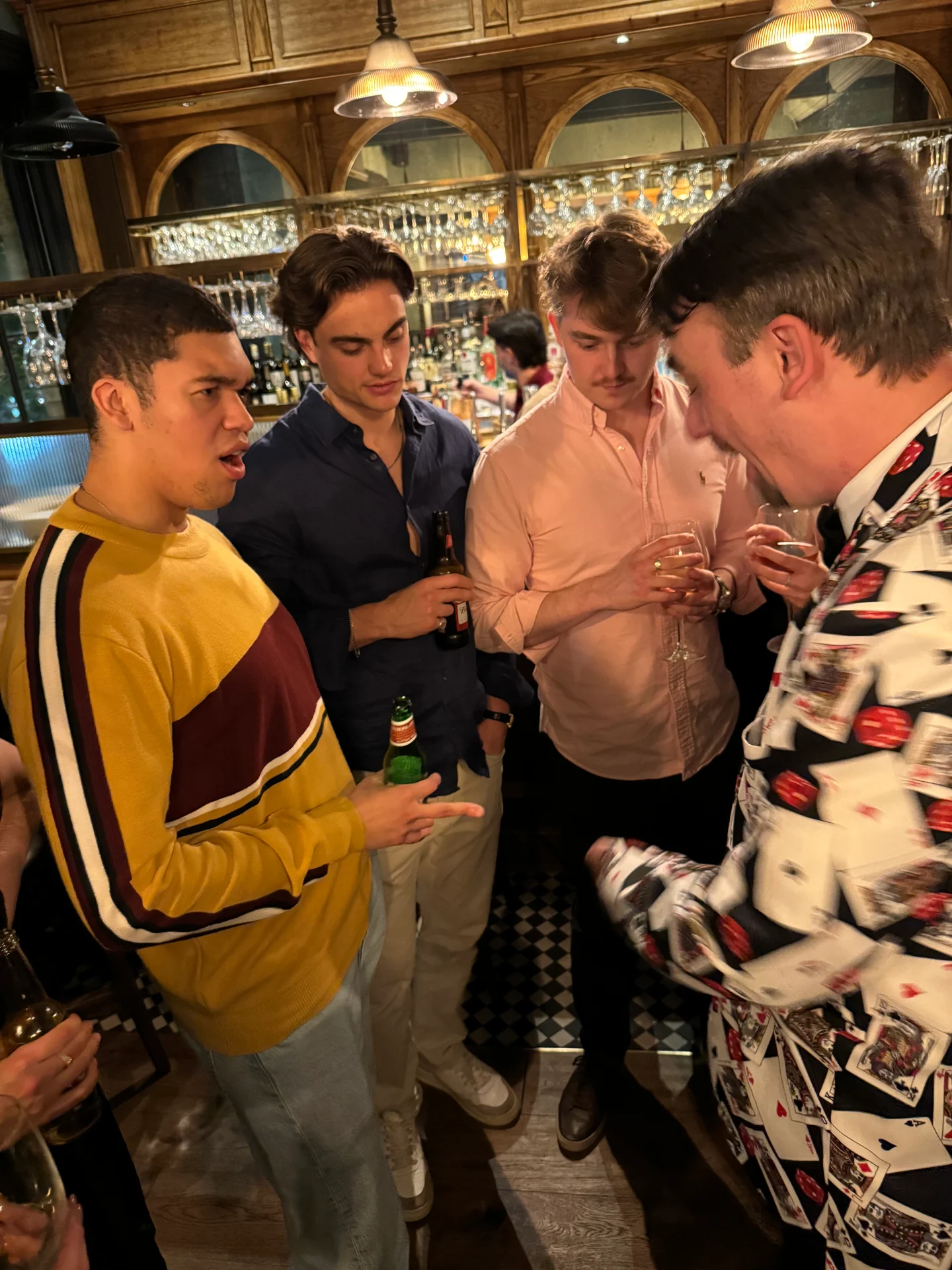 Guests watching Ash Trix perform close-up magic at a party